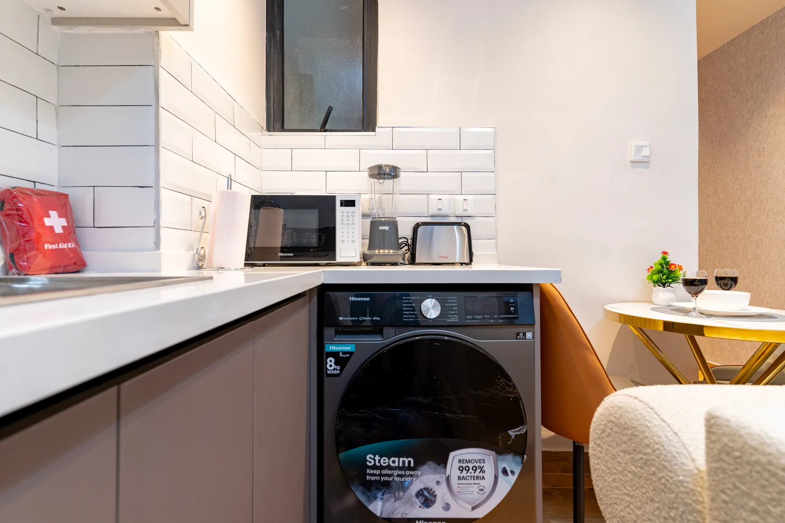 Microwave, blender, toaster and washing machine in the apartment kitchen