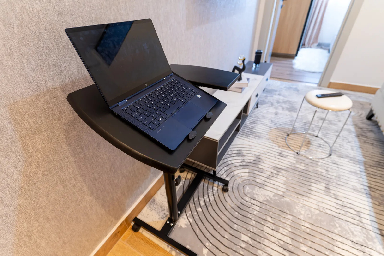 Adjustable laptop stand beside the apartment television console