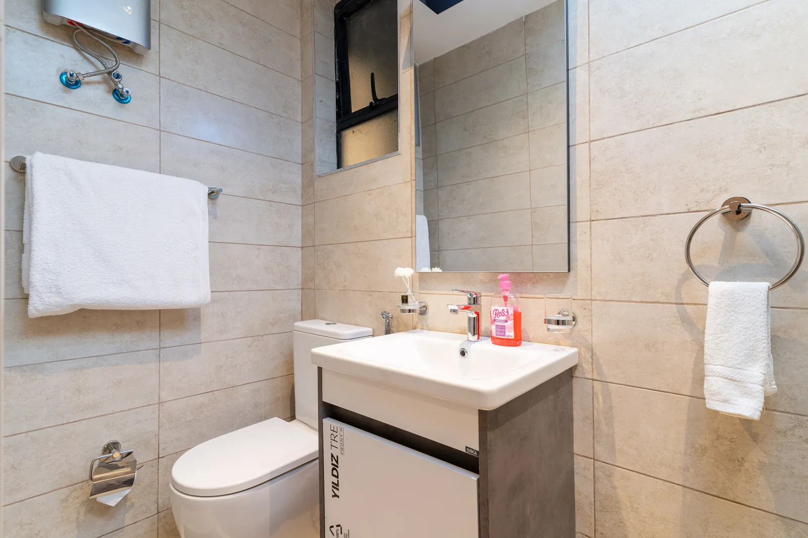 Bathroom vanity, mirror, white towels and hand wash