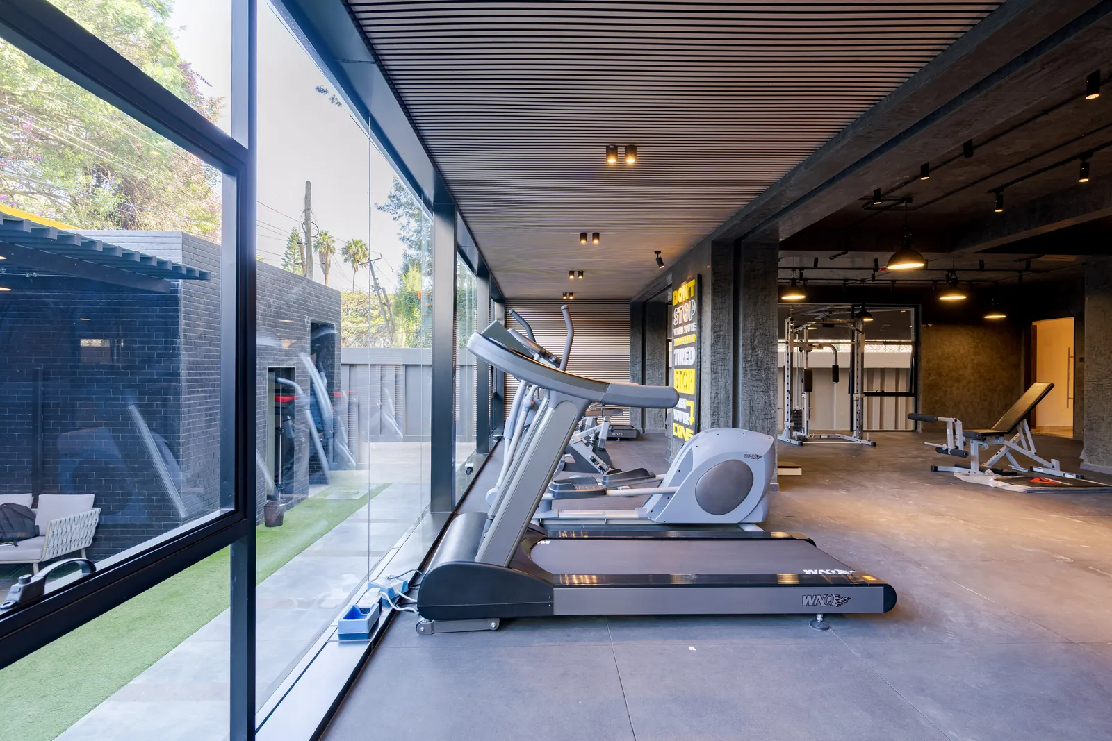 Treadmills and an elliptical trainer beside the gym windows at Wilma