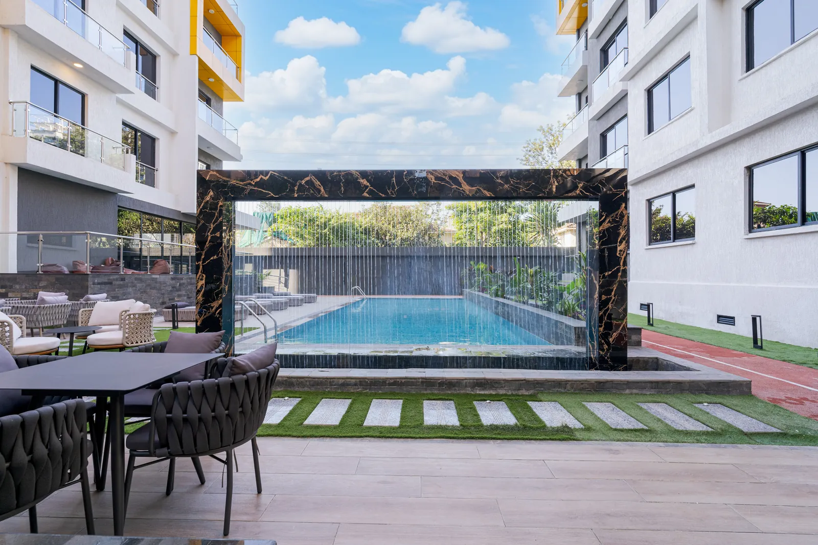 Courtyard swimming pool behind a waterfall feature at Wilma Towers