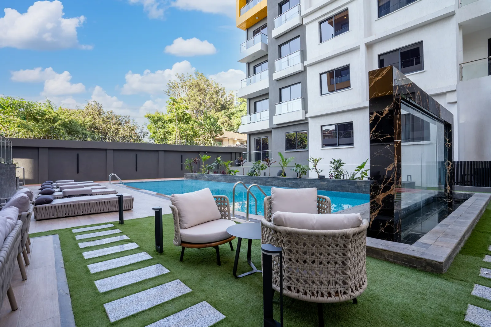 Courtyard armchairs beside the pool and waterfall feature at Wilma Towers