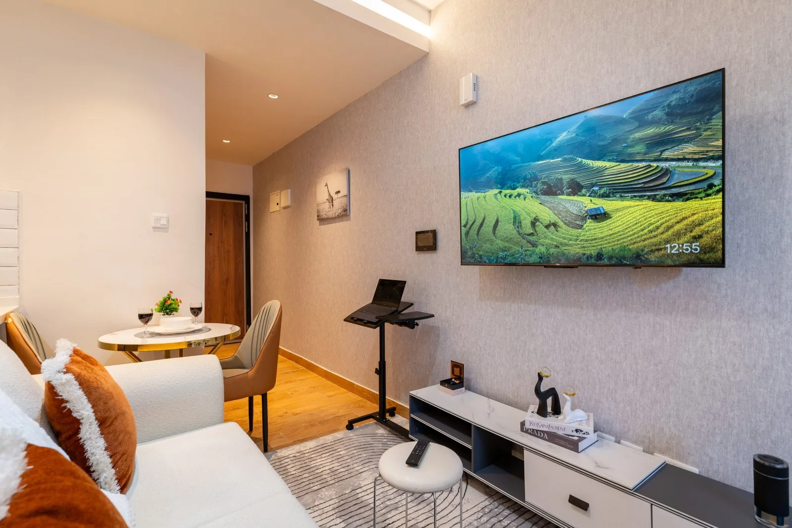 Smart TV, dining table and a laptop stand in the apartment living area
